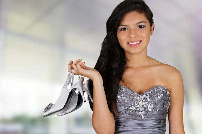Girl at prom with prom shoes in hand